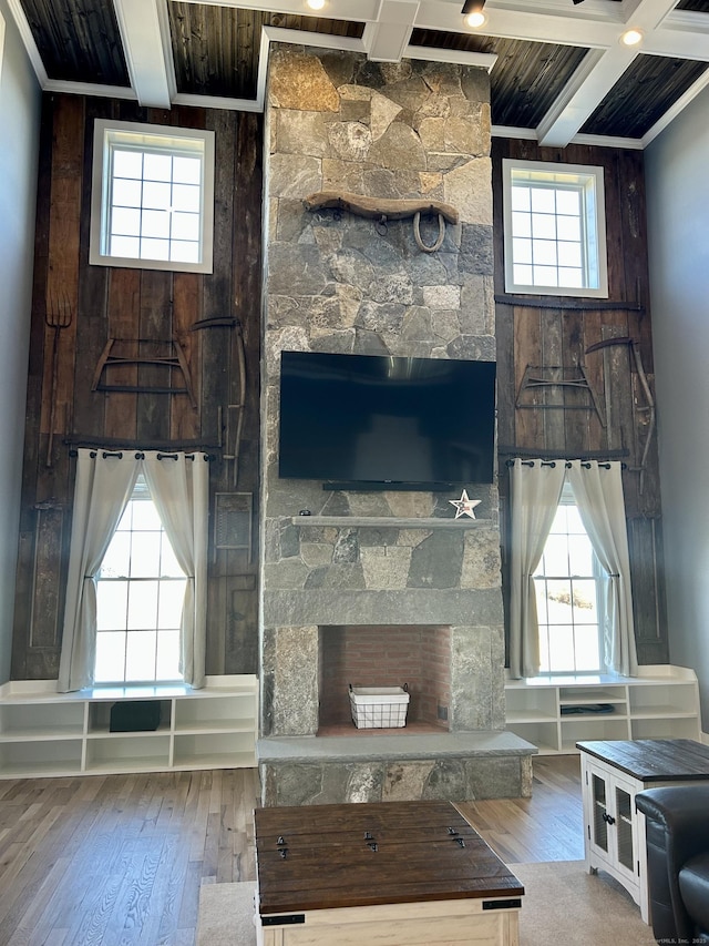 unfurnished living room with beam ceiling, hardwood / wood-style flooring, and a healthy amount of sunlight