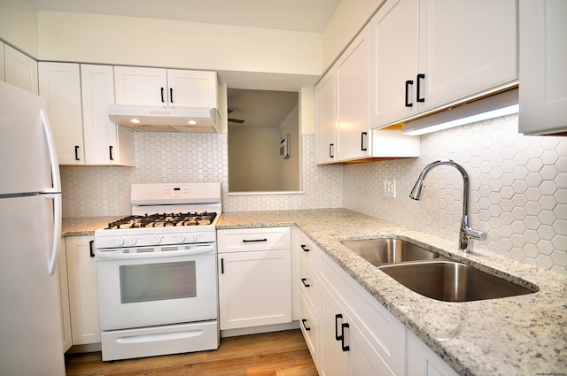 kitchen featuring white appliances, tasteful backsplash, white cabinets, and sink