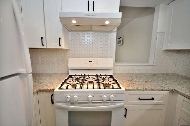 kitchen featuring white appliances, white cabinets, light stone counters, and decorative backsplash