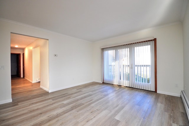 empty room featuring ornamental molding, baseboard heating, and light wood-type flooring