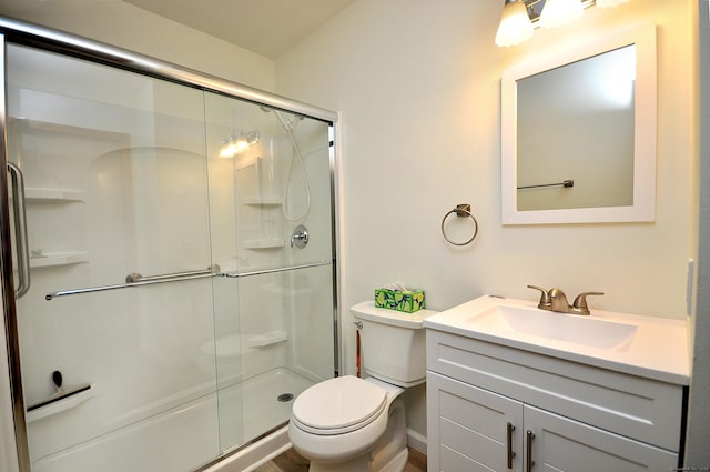 bathroom with an enclosed shower, vanity, and toilet