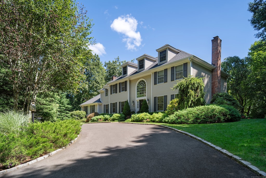 colonial inspired home with a front lawn