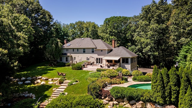 rear view of property with a lawn and a patio