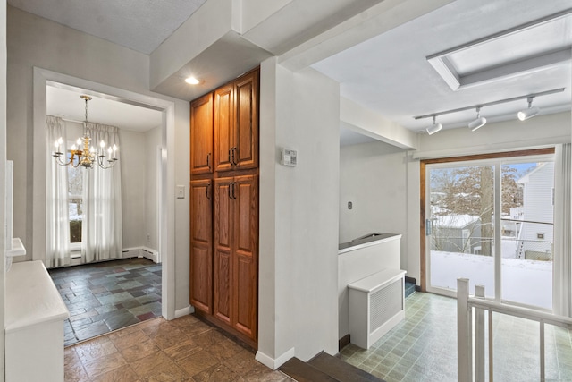 kitchen with a baseboard heating unit, hanging light fixtures, and an inviting chandelier