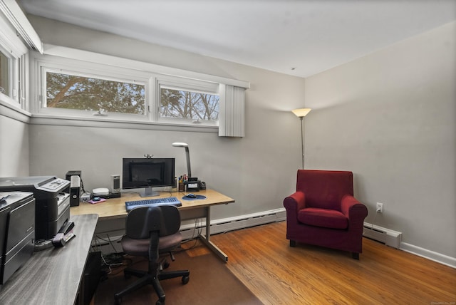 home office with wood-type flooring and a baseboard heating unit