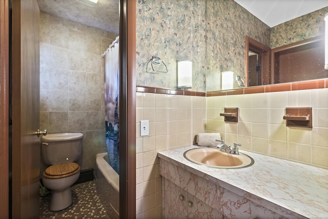 full bathroom with tile patterned floors, shower / bath combination with curtain, sink, toilet, and tile walls