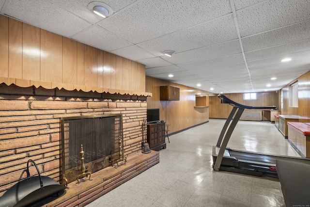 interior space with a stone fireplace and wooden walls