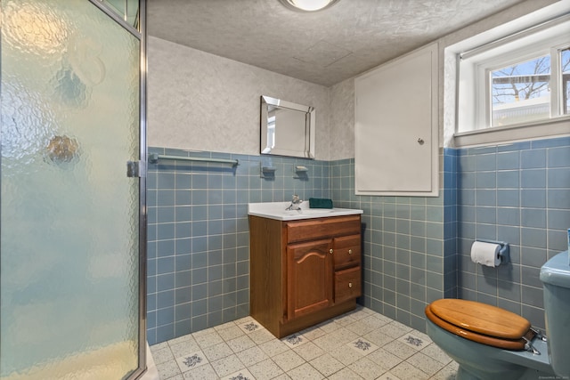 bathroom with an enclosed shower, vanity, toilet, and tile walls