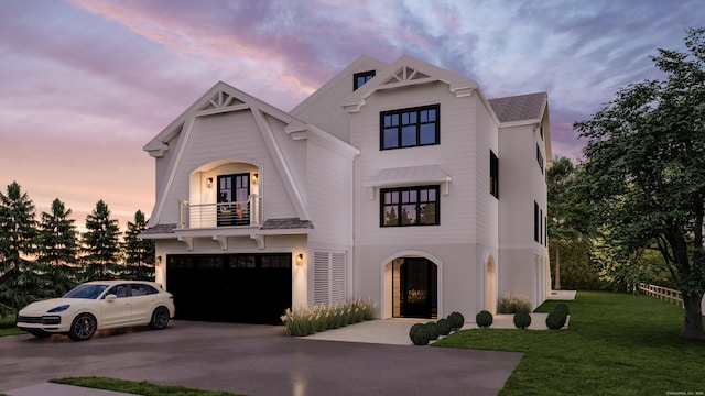 view of front facade featuring a balcony, driveway, a front lawn, and an attached garage