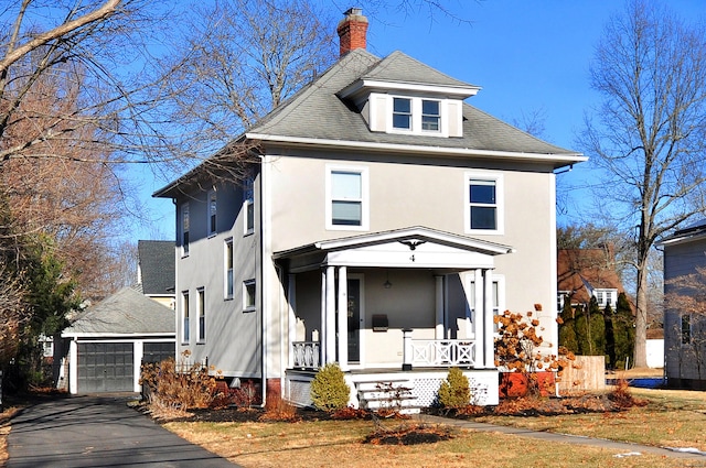 view of front property featuring a garage, an outbuilding, and covered porch