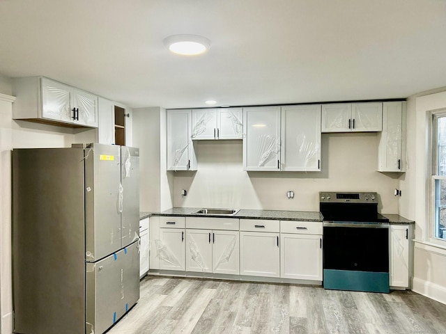 kitchen featuring sink, white cabinets, light hardwood / wood-style flooring, and appliances with stainless steel finishes