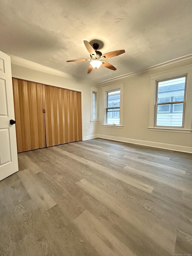 unfurnished bedroom with hardwood / wood-style floors, ceiling fan, and crown molding