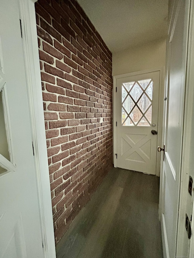 doorway to outside featuring brick wall