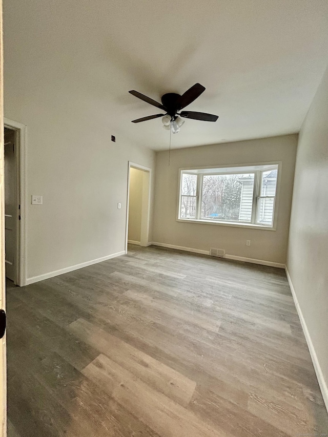 spare room with hardwood / wood-style flooring and ceiling fan