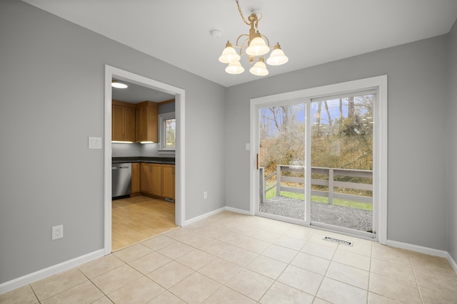 unfurnished dining area featuring light tile patterned floors and an inviting chandelier