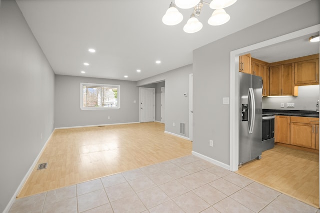 kitchen with a chandelier, appliances with stainless steel finishes, and light tile patterned floors