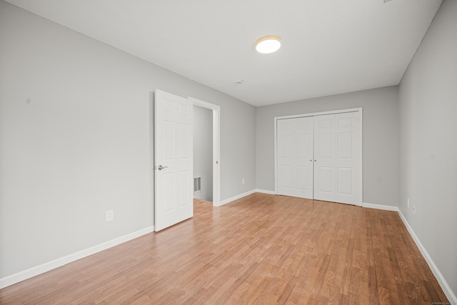 unfurnished bedroom with a closet and light hardwood / wood-style floors