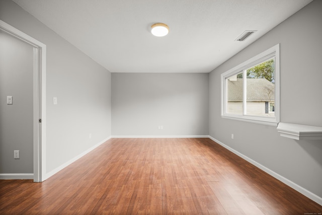 empty room with hardwood / wood-style flooring