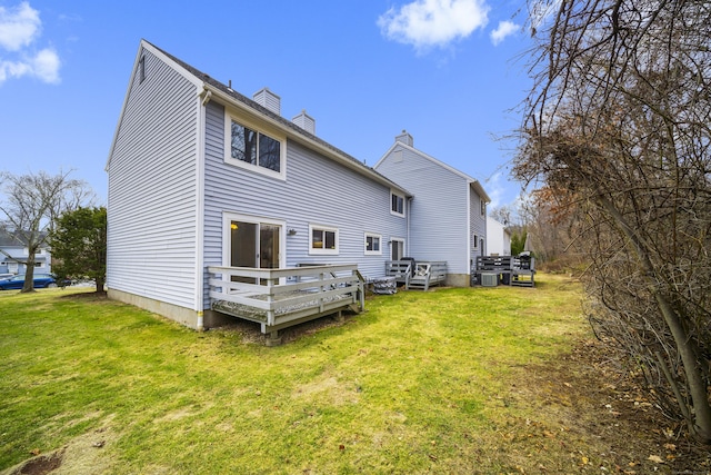 rear view of house featuring a yard and a deck