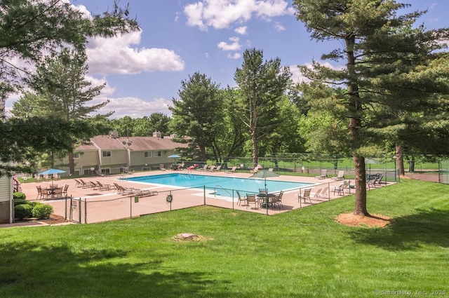 view of swimming pool featuring a patio area and a yard