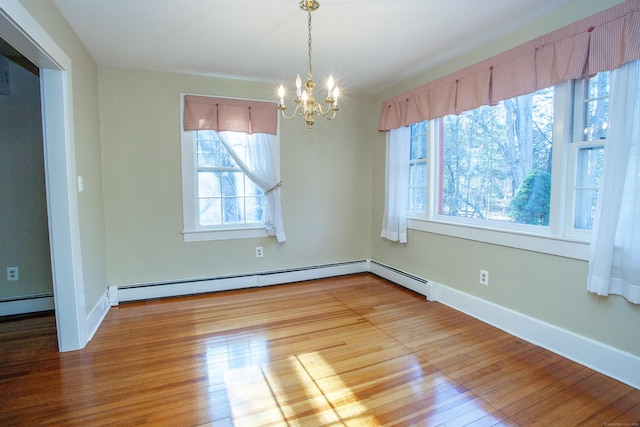 unfurnished dining area featuring a baseboard heating unit, wood-type flooring, and a chandelier