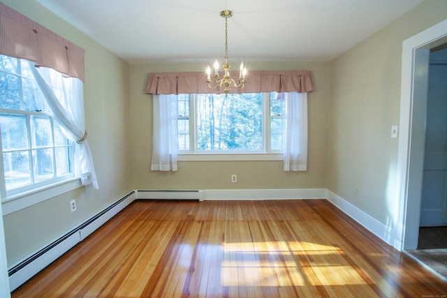 unfurnished dining area with a chandelier, hardwood / wood-style flooring, and baseboard heating