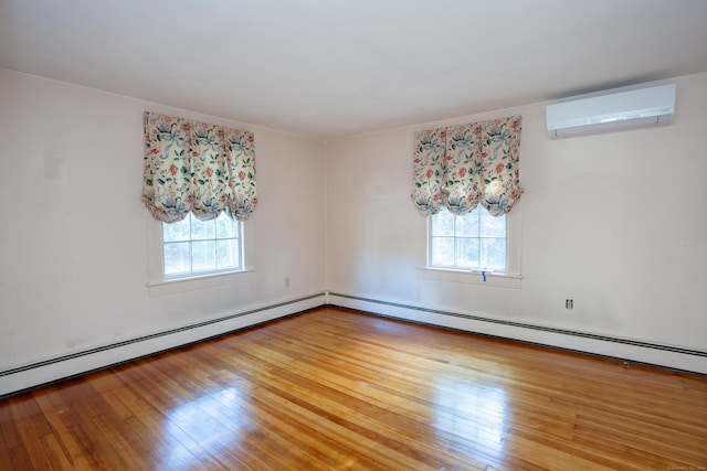 empty room featuring plenty of natural light, a baseboard radiator, wood-type flooring, and a wall mounted air conditioner