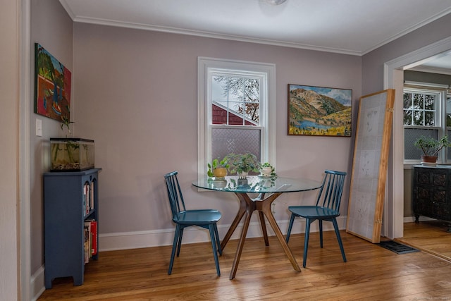 dining room featuring wood-type flooring and crown molding