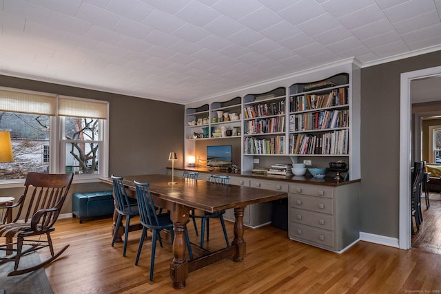 office space featuring crown molding, built in features, and light hardwood / wood-style floors