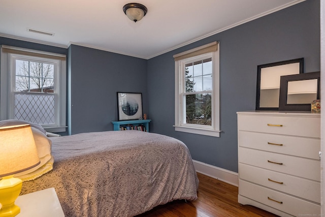 bedroom with dark hardwood / wood-style floors, multiple windows, and crown molding