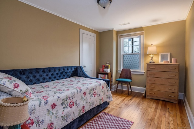 bedroom with light hardwood / wood-style flooring and ornamental molding