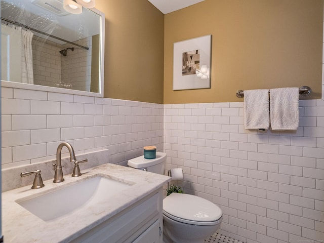 bathroom with vanity, toilet, tile walls, and curtained shower