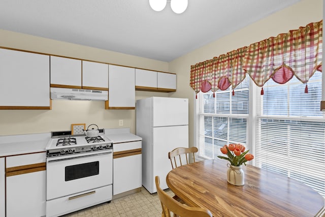 kitchen with white cabinets, white appliances, and a textured ceiling