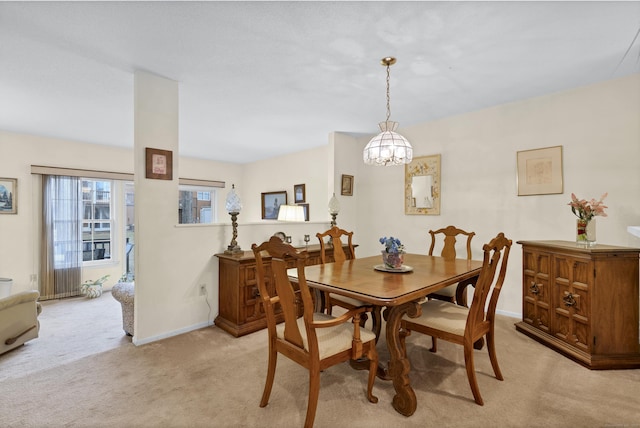 carpeted dining space featuring a chandelier