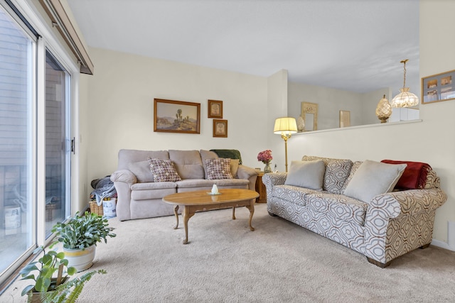 living room featuring carpet floors and a notable chandelier