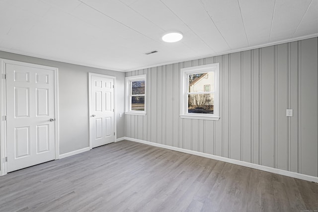 unfurnished bedroom featuring light wood-type flooring and crown molding