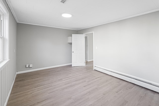 unfurnished room with crown molding, a baseboard radiator, and light wood-type flooring