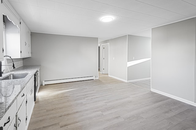 kitchen with a baseboard heating unit, sink, light stone countertops, light wood-type flooring, and white cabinetry