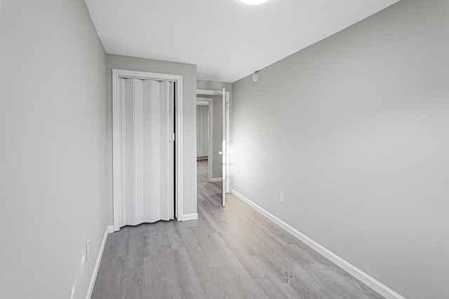 unfurnished bedroom featuring a closet and light wood-type flooring