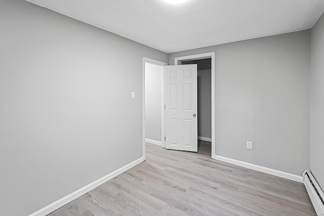 empty room featuring light hardwood / wood-style flooring and a baseboard radiator