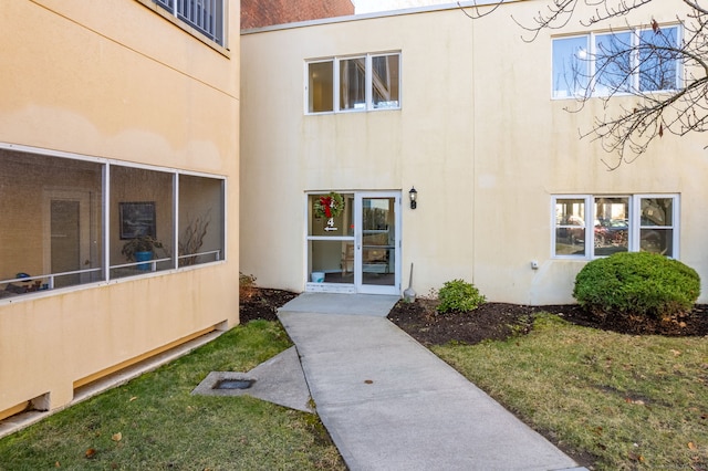 doorway to property with a lawn