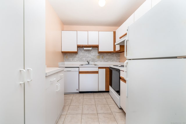 kitchen with white cabinetry, sink, light tile patterned floors, and white appliances