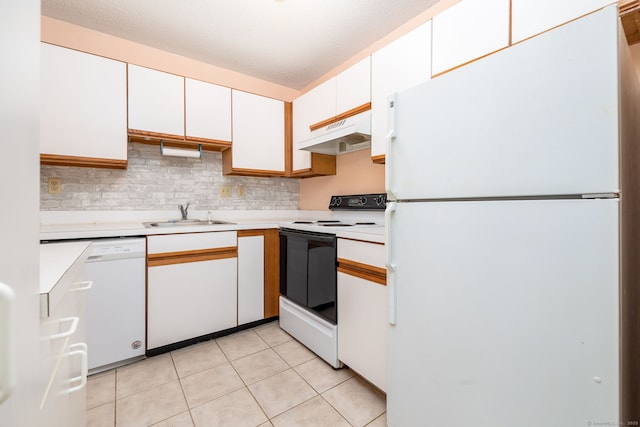 kitchen featuring white appliances, a textured ceiling, sink, light tile patterned floors, and white cabinetry