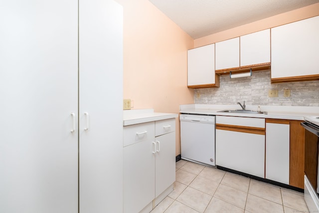 kitchen with dishwasher, white cabinets, sink, light tile patterned floors, and a textured ceiling