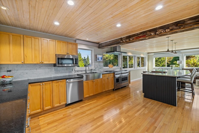 kitchen with sink, decorative light fixtures, wooden ceiling, appliances with stainless steel finishes, and wall chimney range hood