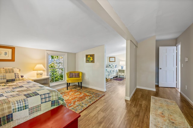 bedroom with vaulted ceiling and hardwood / wood-style floors