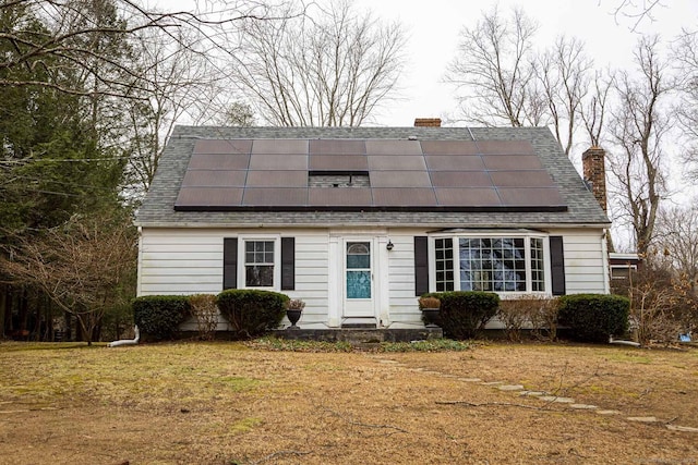 view of front facade with a front yard and solar panels