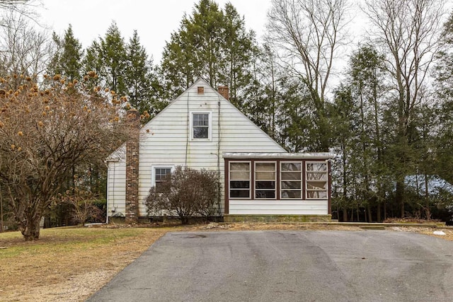 view of property exterior with a sunroom