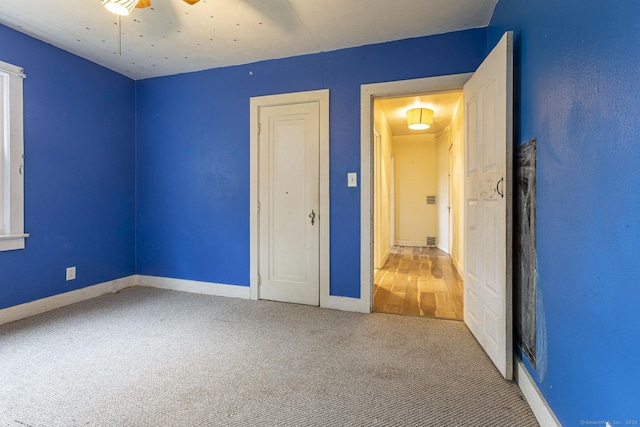 carpeted empty room featuring ceiling fan