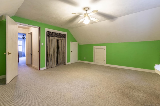 additional living space featuring carpet, ceiling fan, and vaulted ceiling